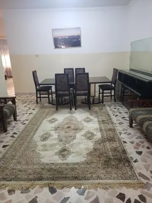a dining room with chairs and a table and a piano at Alotaibi bulding in Amman