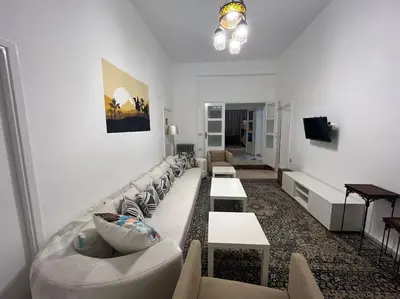a living room with couches and tables and a television at B Beitna in Amman