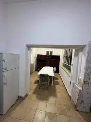 a white room with a table and a refrigerator at B Beitna in Amman