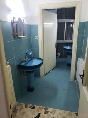 a bathroom with two blue sinks in a room at ALOTAIBI bulding # 6 in Amman