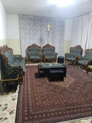 a living room with chairs and a table and a rug at ALOTAIBI bulding # 6 in Amman