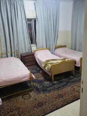 a room with two beds and a rug at ALOTAIBI bulding # 6 in Amman