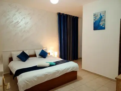a bedroom with a large bed with blue pillows at Jordan River hotel in Amman