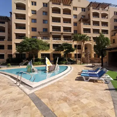 a swimming pool with lounge chairs in front of a building at E23 Luxury - Full Sea view-Samra Resort in Sowayma