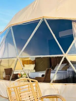 a tent with chairs and a bed in it at Camille WadiRum Camp in Disah