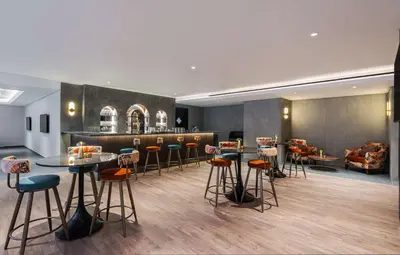 a bar with stools and tables in a room at Doubletree By Hilton Amman Hotel & Residences in Amman