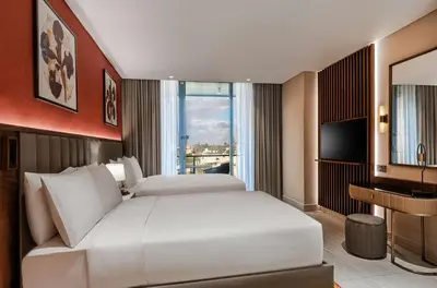 a bedroom with a large white bed and a television at Doubletree By Hilton Amman Hotel & Residences in Amman