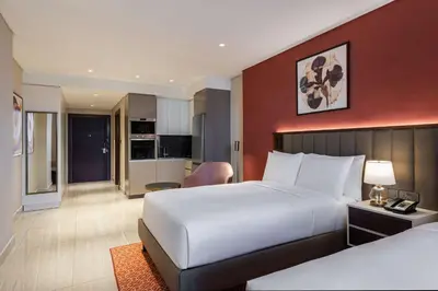 a hotel room with a bed and a living room at Doubletree By Hilton Amman Hotel & Residences in Amman