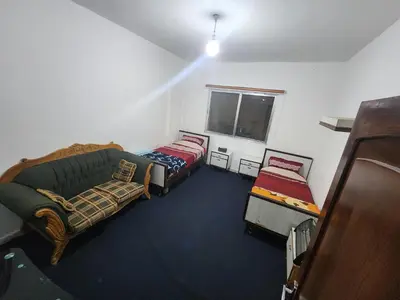 a living room with two beds and a couch at Artemis Hotel in Jerash