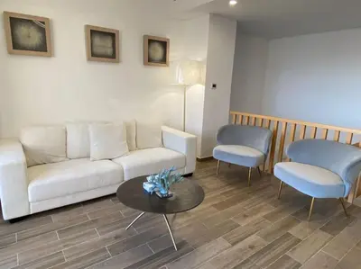 a living room with a couch and two chairs and a table at Lovely 2-Bedroom with pool in the heart of Aqaba in Aqaba