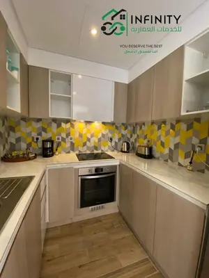 a kitchen with yellow and white tiles on the wall at Lovely 2-Bedroom with pool in the heart of Aqaba in Aqaba