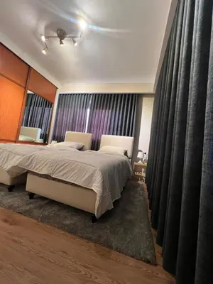 a bedroom with a bed and a large window at Amman Central Cozy Apartment in Amman