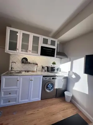 a kitchen with a sink and a washing machine at Amman Central Cozy Apartment in Amman