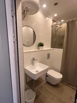 a bathroom with a sink and a toilet and a mirror at Amman Central Cozy Apartment in Amman