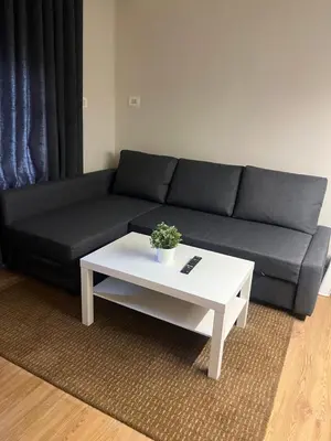 a living room with a black couch and a white coffee table at Amman Central Cozy Apartment in Amman