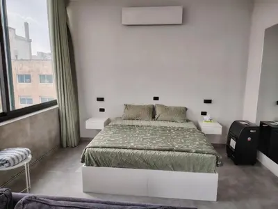 a bedroom with a bed and a large window at Abu alzoz rooftop 2 in Amman