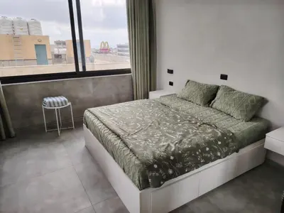 a bedroom with a bed and a large window at Abu alzoz rooftop 2 in Amman