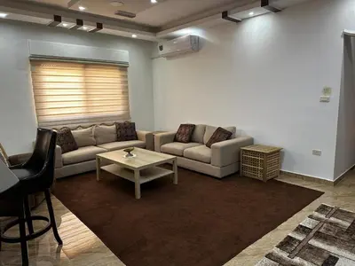 a living room with a couch and a table at 8-New and Spacious Apartments Close to Market in Amman