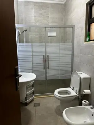 a bathroom with a shower and a toilet and a sink at 8-New and Spacious Apartments Close to Market in Amman