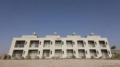 a building on the beach with a blue sky at Azraq Lodge in Al Azraq ash Shamālī