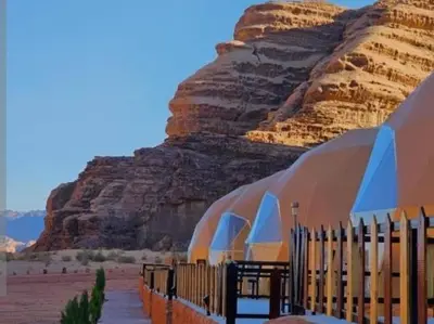 a building in the desert with a mountain in the background at Ayman camp in Wadi Rum