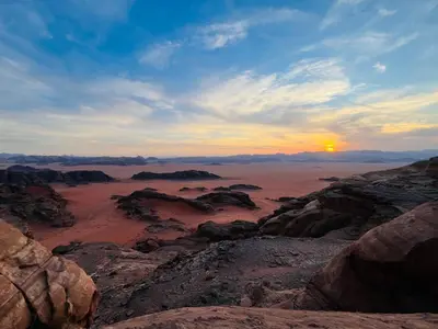 a view of the desert with the sun setting at Emad wadi rum camp in Wadi Rum