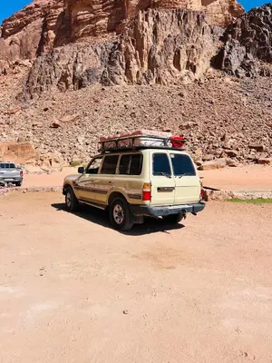 a suv parked on a dirt road in the desert at Emad wadi rum camp in Wadi Rum