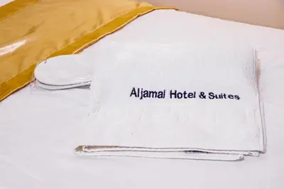 a towel with the alhambra hotel and suites on a bed at Al Jamal Suites in Amman