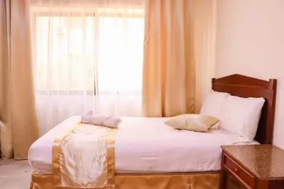 a bedroom with a bed with a large window at Al Jamal Suites in Amman