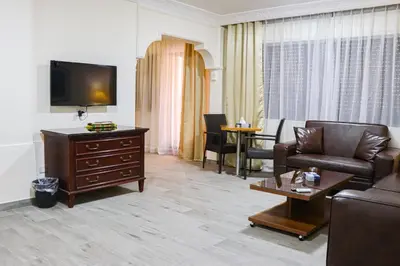 a living room with a couch and a tv at Al Jamal Suites in Amman