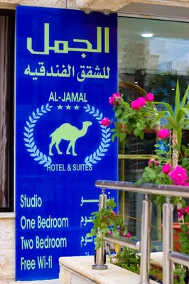 a blue sign for a hotel and suites at Al Jamal Suites in Amman