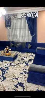 a room with a blue couch and a table with a blue and white carpet at Jordan in Irbid
