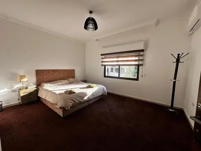 a bedroom with a large bed and a window at 5-New and Spacious Apartments Close to Market in Rujm ash Sharāʼirah