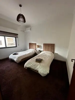 a bedroom with two beds in a room at 5-New and Spacious Apartments Close to Market in Rujm ash Sharāʼirah