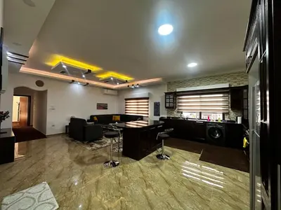 a living room with a couch and a table at 5-New and Spacious Apartments Close to Market in Rujm ash Sharāʼirah