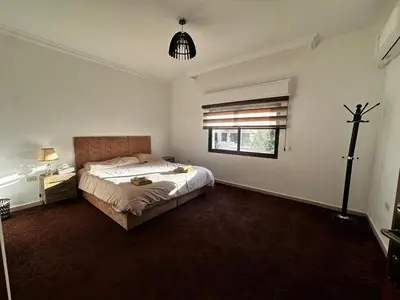a bedroom with a large bed and a window at 5-New and Spacious Apartments Close to Market in Rujm ash Sharāʼirah