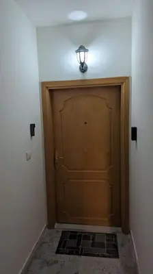 a large wooden door with a light above it at Modern Flat in Heart of Amman in Amman