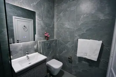 a bathroom with a sink and a toilet and a mirror at Modern Flat in Heart of Amman in Amman