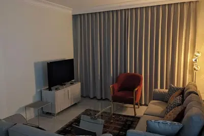 a living room with a couch and a television at Modern Flat in Heart of Amman in Amman