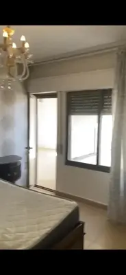a bedroom with a bed and two windows in it at Omar in Al Bunayyāt ash Shamālīyah