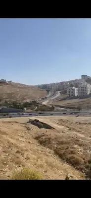 a view of a desert with buildings in the background at Omar in Al Bunayyāt ash Shamālīyah