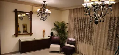 a bathroom with a chandelier and a chair and a tub at Luxuries Furnished Apartment in Shmeisani in Amman