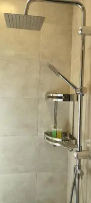 a bathroom with a shower with two shelves on the wall at Blue Stone H in Madaba