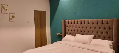 a bedroom with a bed and a green wall at Blue Stone H in Madaba