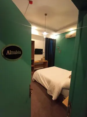 a bedroom with a bed and a green wall at Blue Stone H in Madaba