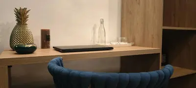 a desk with a blue chair next to a table with a vase at Blue Stone H in Madaba