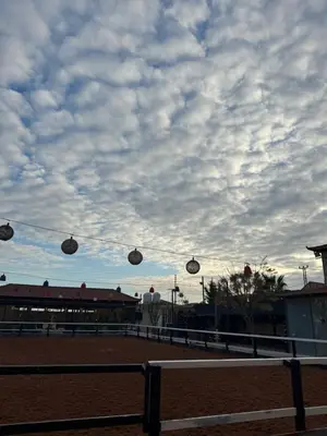 a cloudy sky with weights on a fence in a horse arena at Golden Horse Chalet And Club in Maḩaţţat al Jīzah
