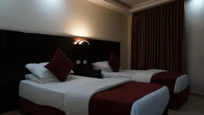 a hotel room with two beds with red and white pillows at فندق ملتقى البتراء in Wadi Musa