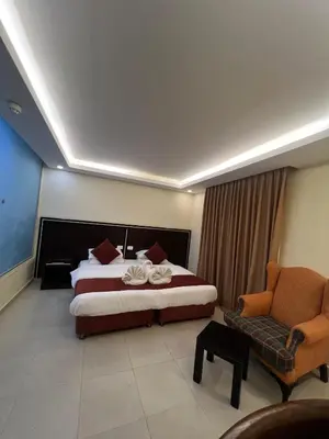 a hotel room with a bed and a chair at فندق ملتقى البتراء in Wadi Musa