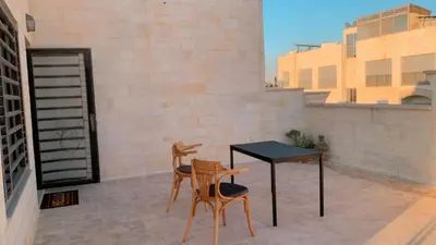a patio with a table and chairs on a balcony at Rooftop View in Amman